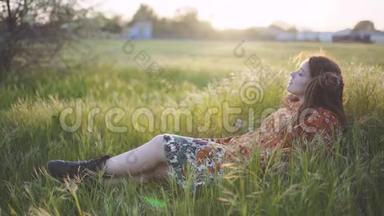 美丽的嬉皮士女人，在日落时带着绿草中的可怕的怪物，在户外玩得很开心